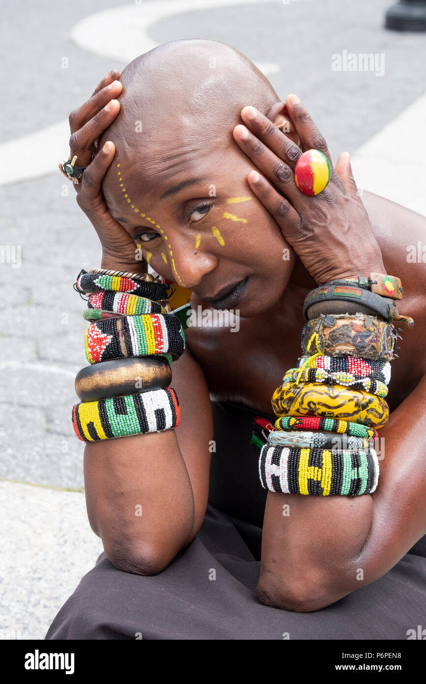 A beautiful woman wearing approximately 18 bracelets on a warm day in Union Square Park in Manhattan, New York City Stock Photo