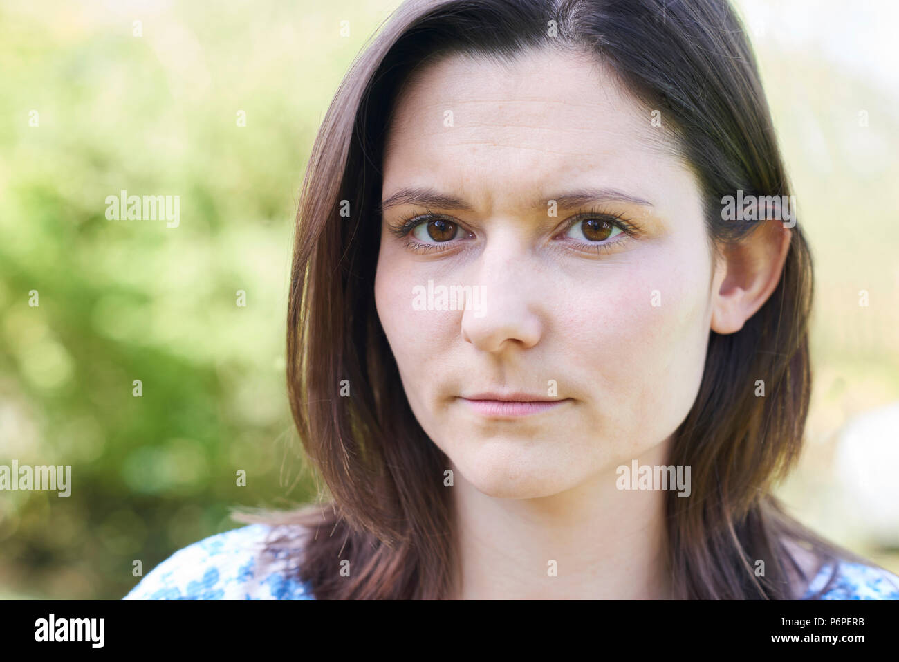 Outdoor Head And Shoulder Portrait Of Worried Young Woman Stock Photo