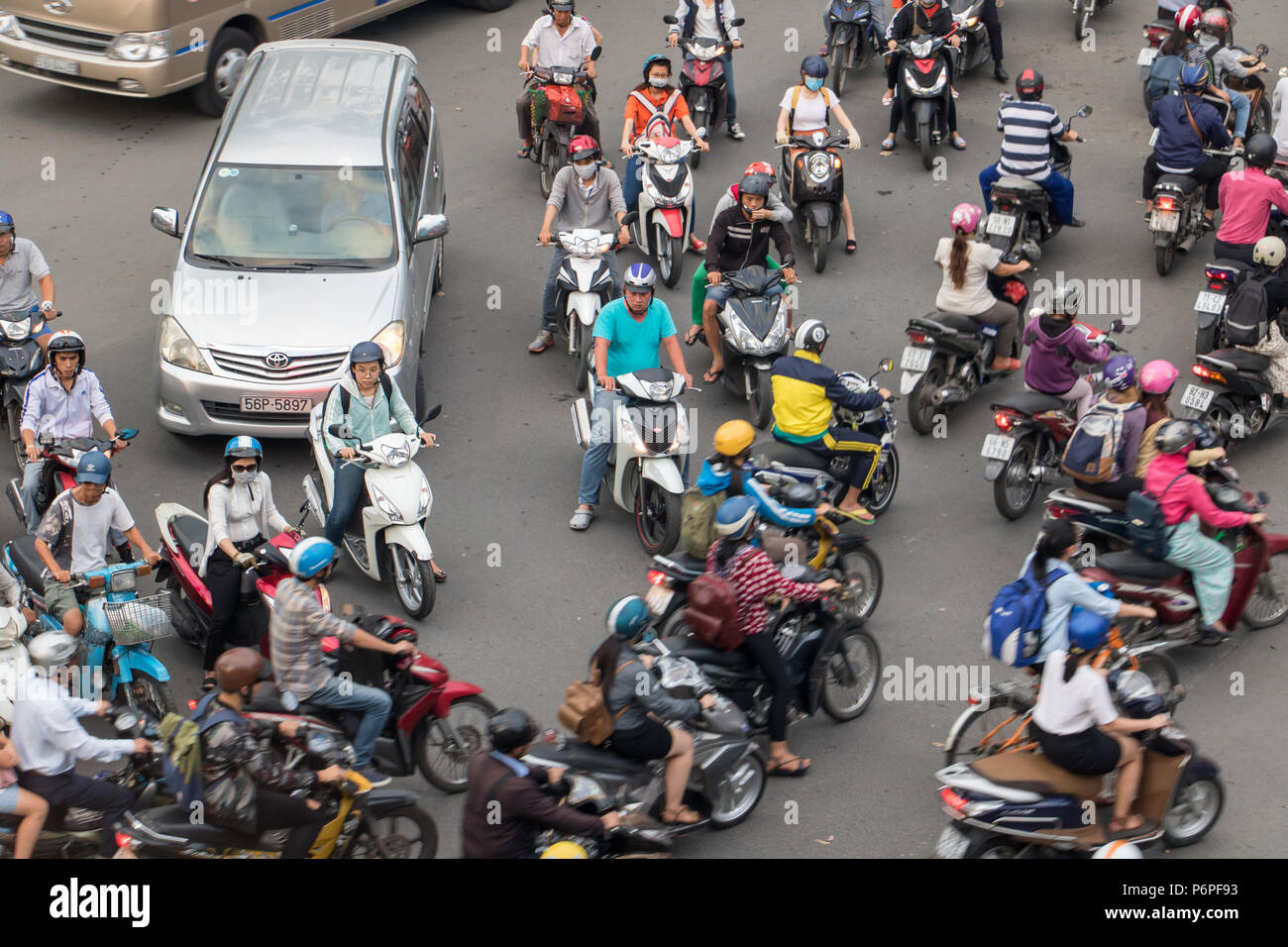 SAIGON, VIETNAM, DEC 14 2017, Dense traffic at intersection with passing through motorbikes and vehicles. Stock Photo
