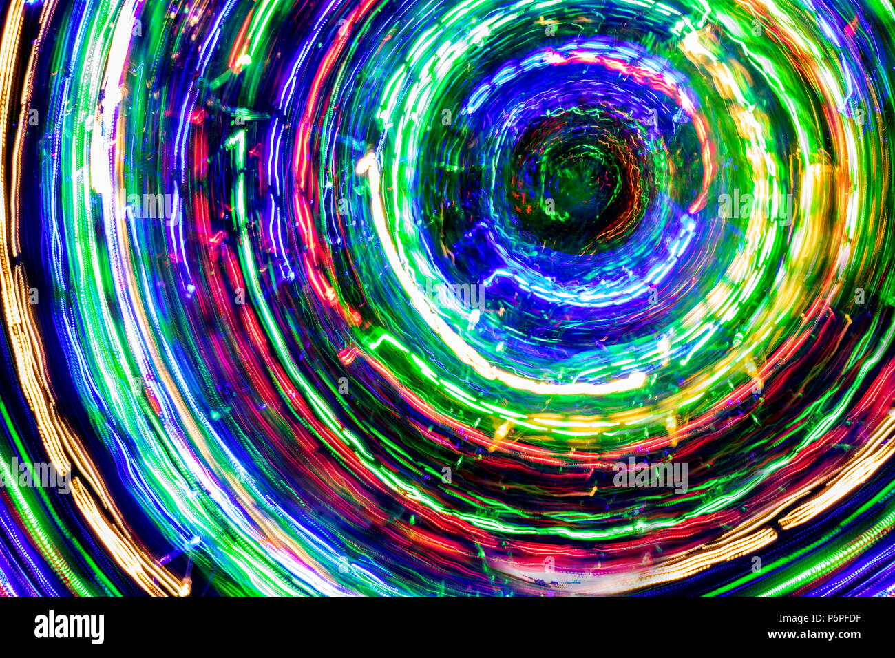 The round of blurred lines of color lights on dark background. Colorful lights blurred by motion. Stock Photo