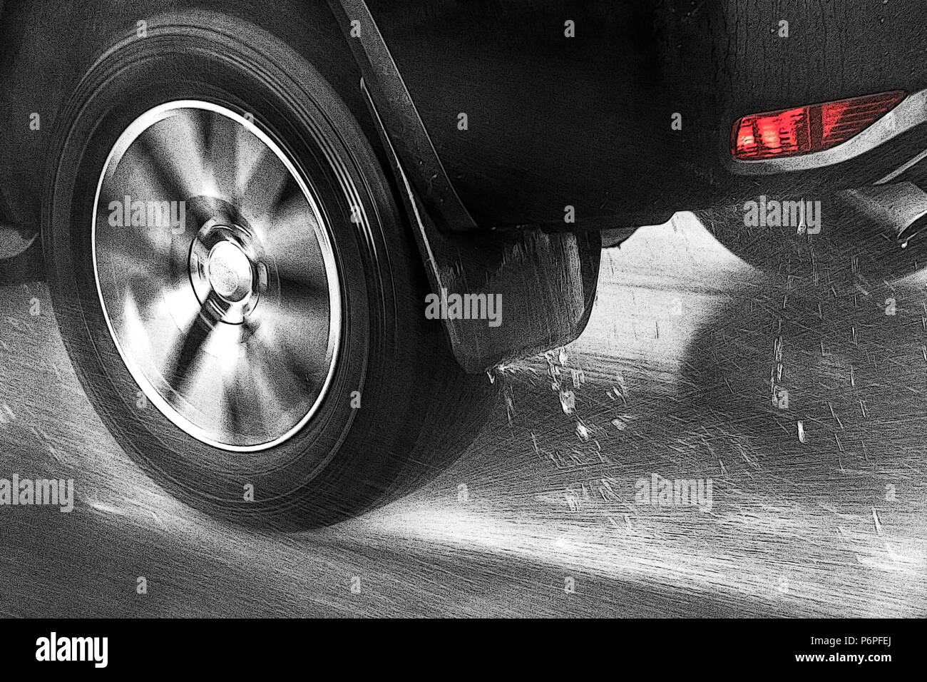 Detail of the rear wheel of a car driving in the rain on a wet road. Aquaplaning in road traffic. Stock Photo