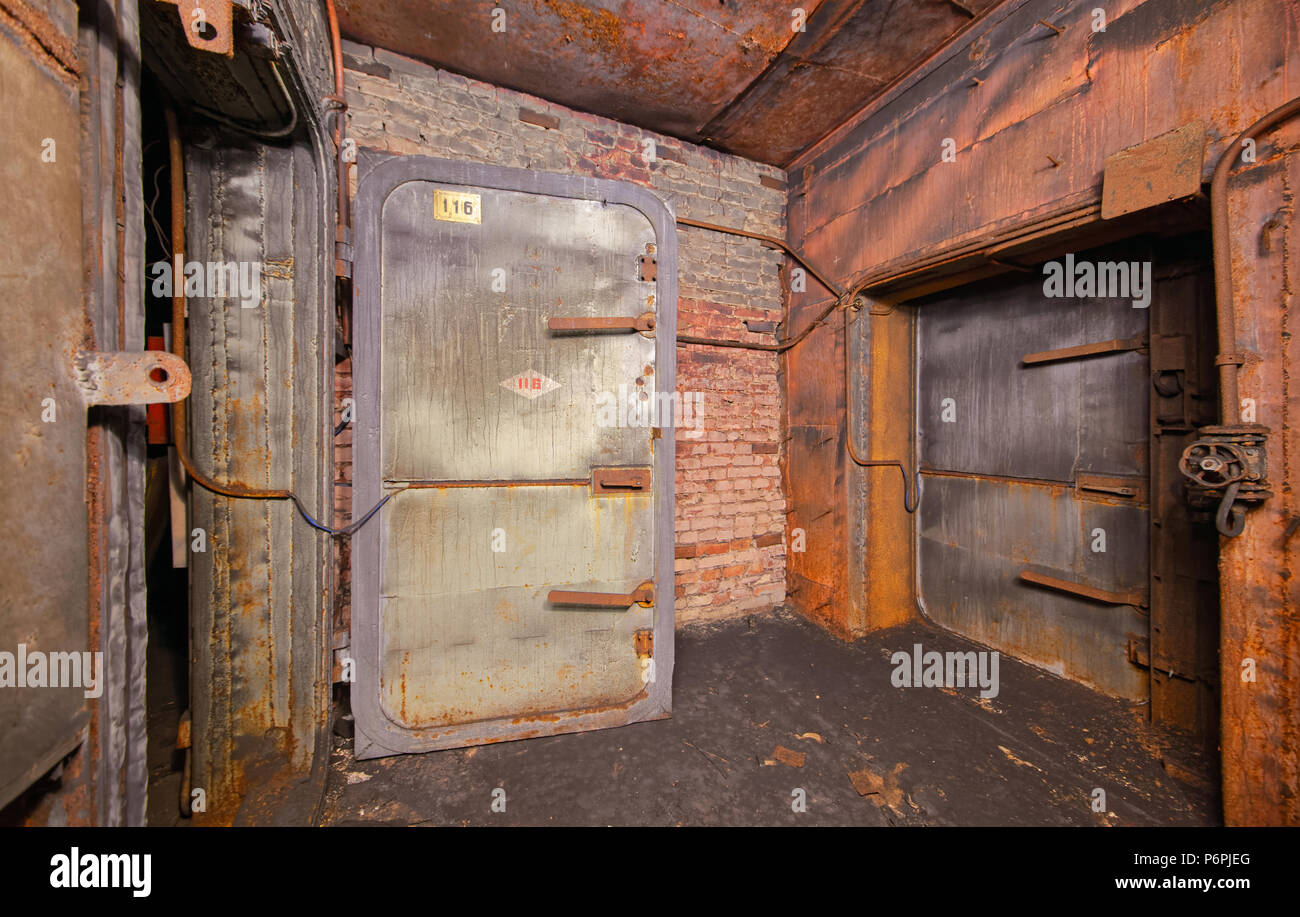 Old rusty armored iron door in a burnt - out industrial building Stock Photo