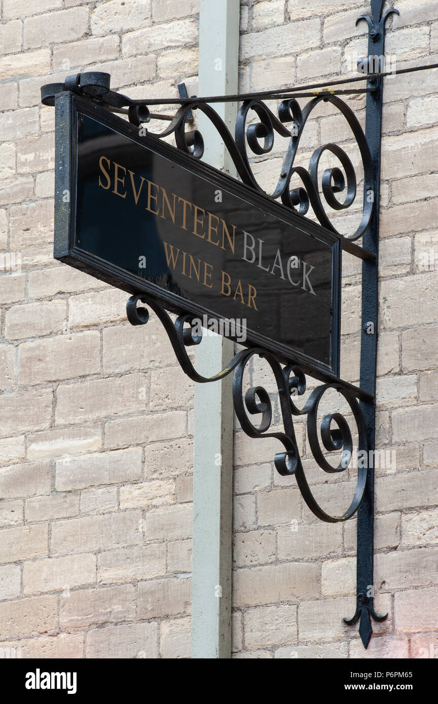 A hanging shop sign for a wine bar incorporating a number and a ...