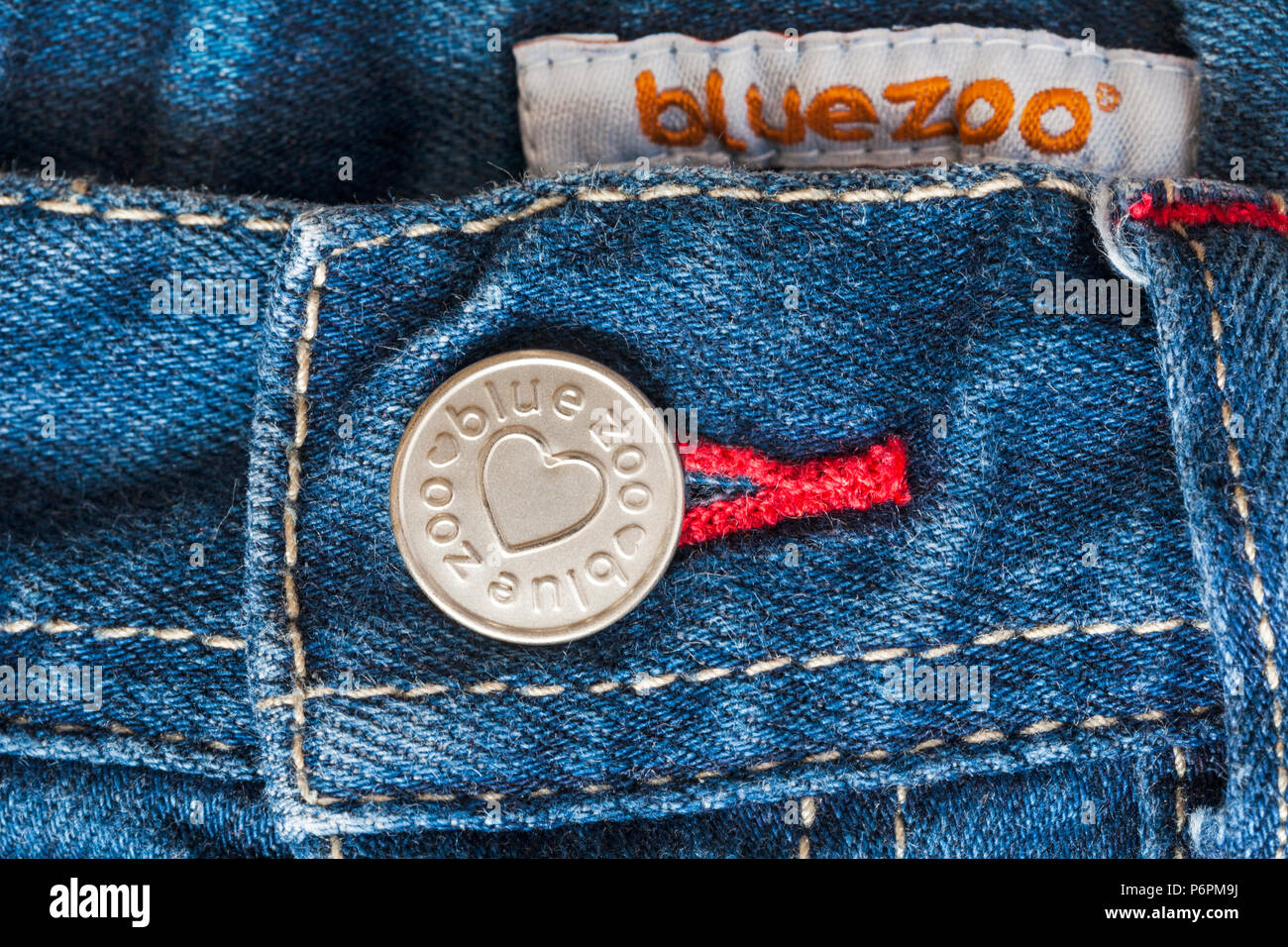 Blue zoo button and blue zoo label in denim jeans Stock Photo - Alamy