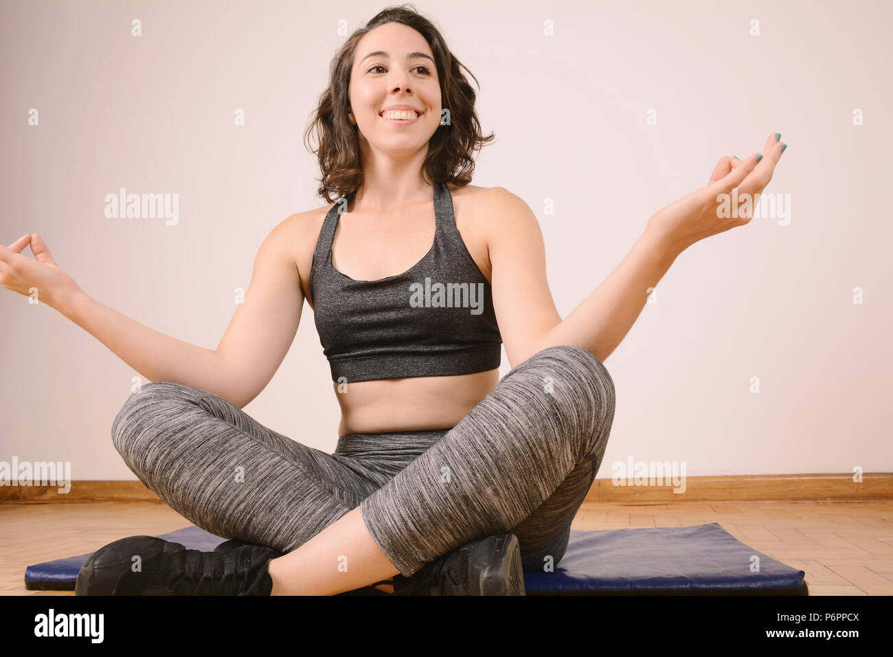 Young attractive woman sitting in Half Lotus pose. Yoga concept Stock ...