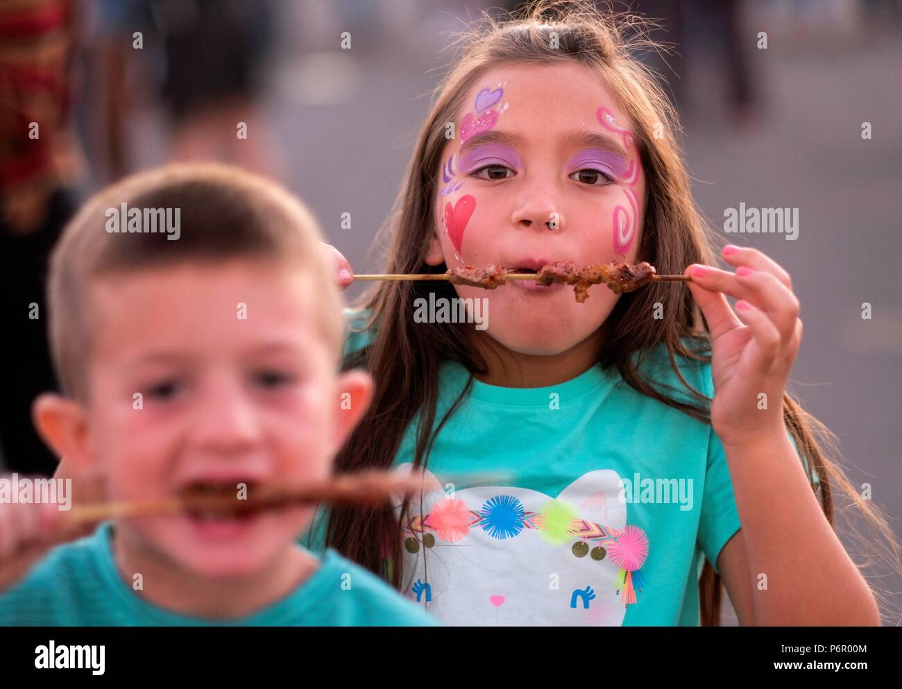 (180702) -- ARCADIA, July 2, 2018 (Xinhua) -- Children enjoy food at the '626 Night Market' in Arcadia, California, the United States on July 1, 2018. '626' is the area code of San Gabriel Valley in Los Angeles, a region with lots of Chinese. From dozens of booths to hundreds of vendors, in recent years, the '626 Night Market' has become the largest night market in the United States and a part of the urban culture in Los Angeles. (Xinhua/Zhao Hanrong) (zxj) Stock Photo