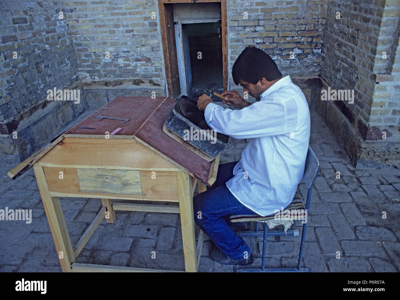 In an Islamic madrasah, a restaurateur is working on an old metal bowl, undated analogue photograph from October 1992. The historical, mostly Islamic center of Bukhara was declared a UNESCO World Heritage Site in 1993, and the state of Uzbekistan gained its independence after the collapse of the Soviet Union on 01.09.1991. Photo: Matthias Toedt/dpa central image/ZB/picture alliance | usage worldwide Stock Photo