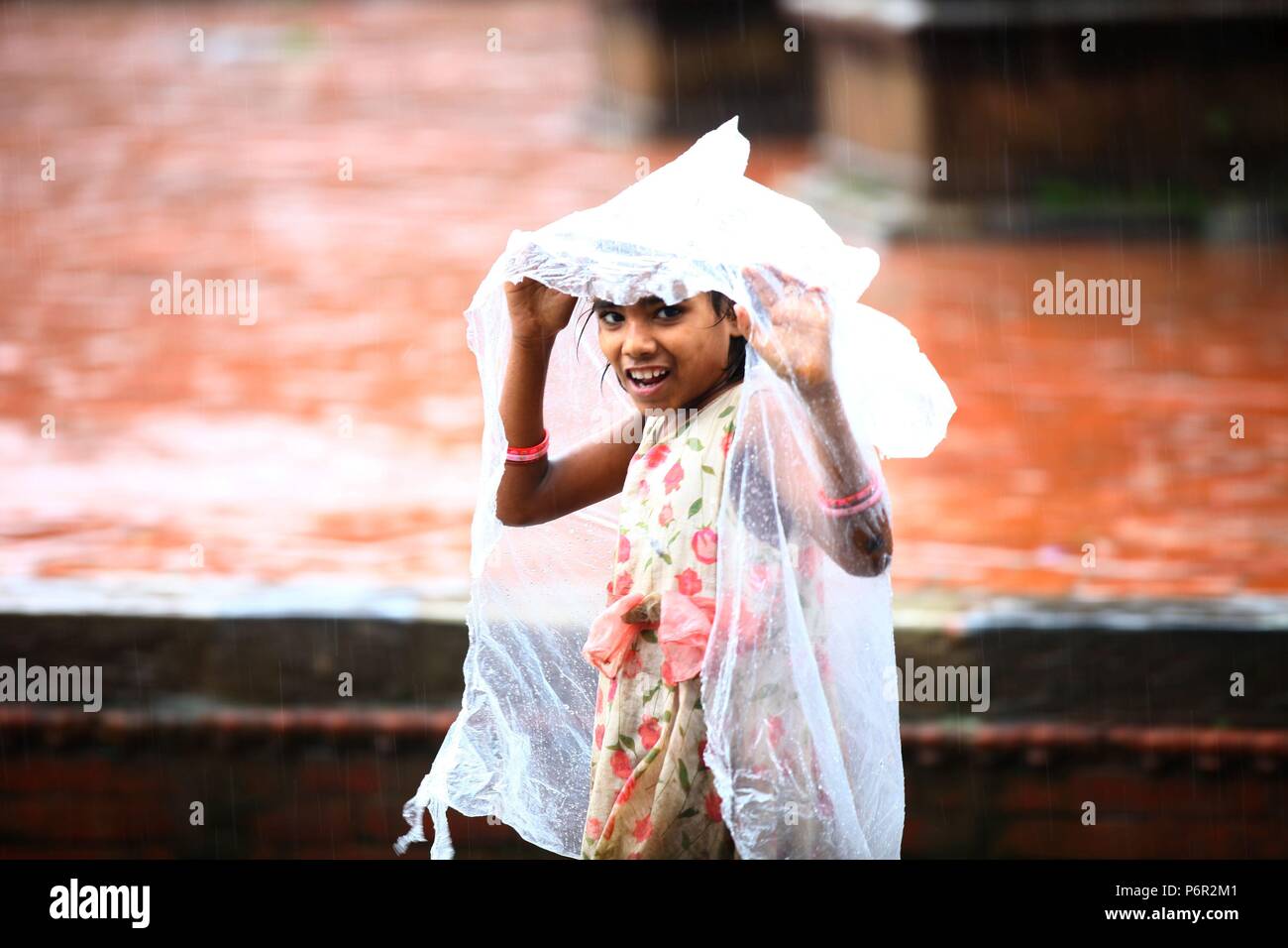 Kathmandu, Nepal. 2nd July, 2018. A girl smiles as she walks with a