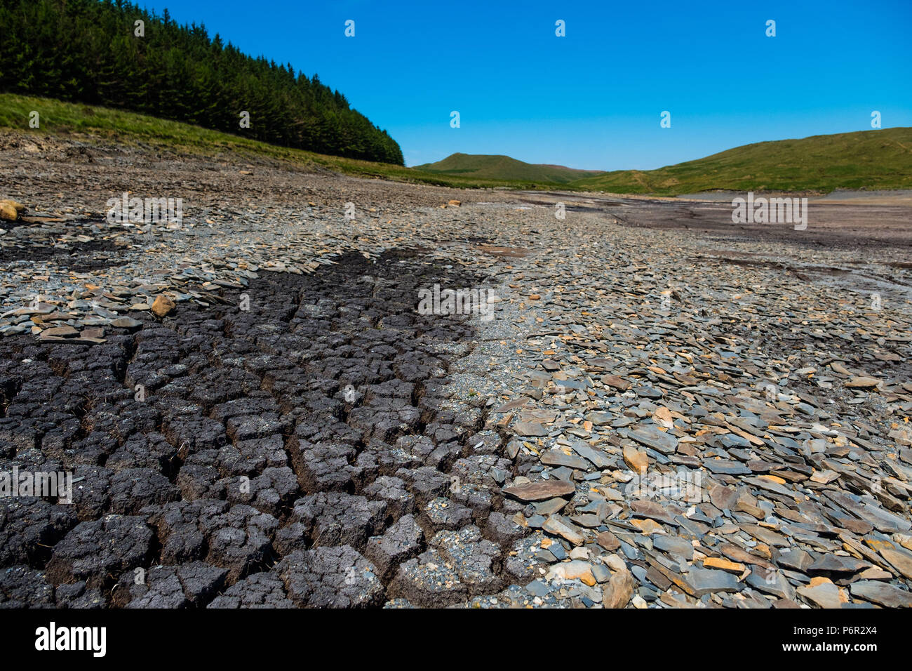 Nant y Moch, Ceredigion, Wales UK, 02 July 2018  UK Weather: After a very long dry and hot spell of weather,  the reservoir at Nant y Moch, just inland of Aberystwyth, has fallen to dramatically low levels last seen in the long hot summer of 1976.  Already, some local properties the nearly village of Ponterwyd, , that draw their water from  wells and springs, have seen their water supplies dry up and disappear   photo credit Keith Morris / Alamy Live News Stock Photo