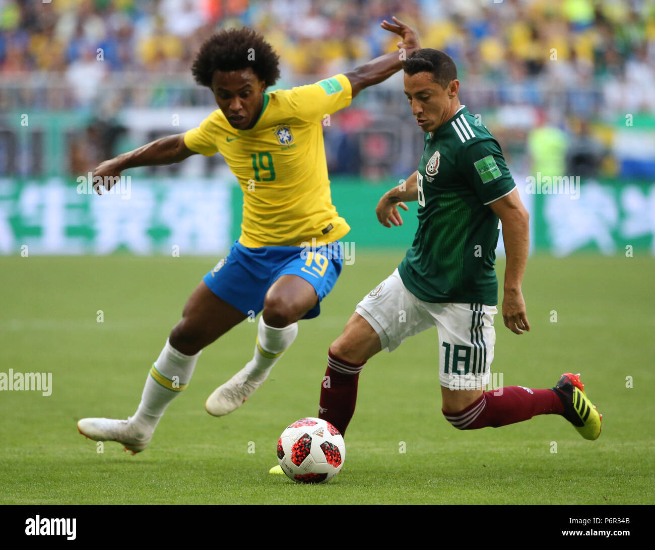 Samara, Russia. 2nd July, 2018. Willian (L) of Brazil vies with Andres Guardado of Mexico during the 2018 FIFA World Cup round of 16 match between Brazil and Mexico in Samara, Russia, July 2, 2018. Credit: Li Ming/Xinhua/Alamy Live News Stock Photo