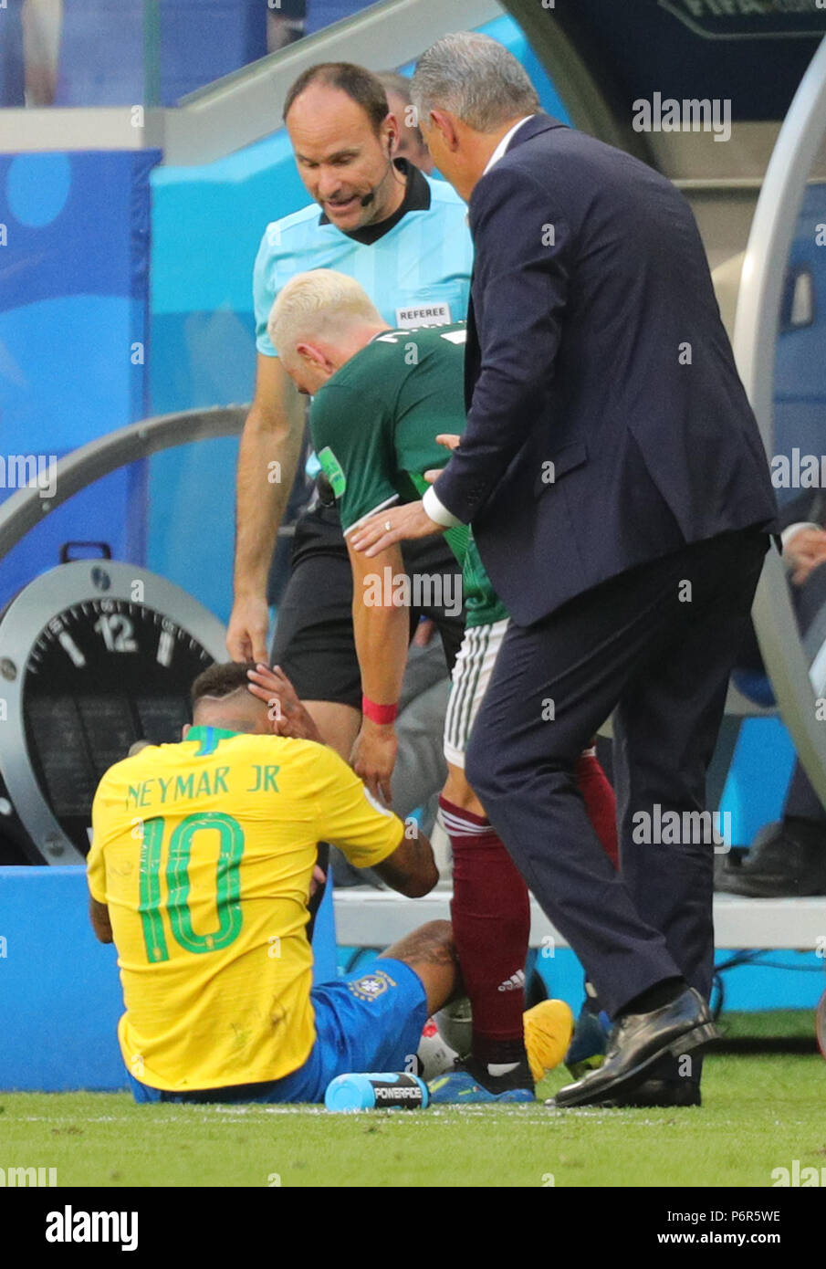 Samara, Russia. 02nd July, 2018. Soccer, World Cup 2018, Final round - round of 16: Mexico vs. Brazil at the Samara stadium: Brazil's Neymar (L) sitting on the floor after a duel while Mexico's Miguel Layun (C) and Brazil head coach Tite (R) argue. Credit: Christian Charisius/dpa/Alamy Live News Stock Photo