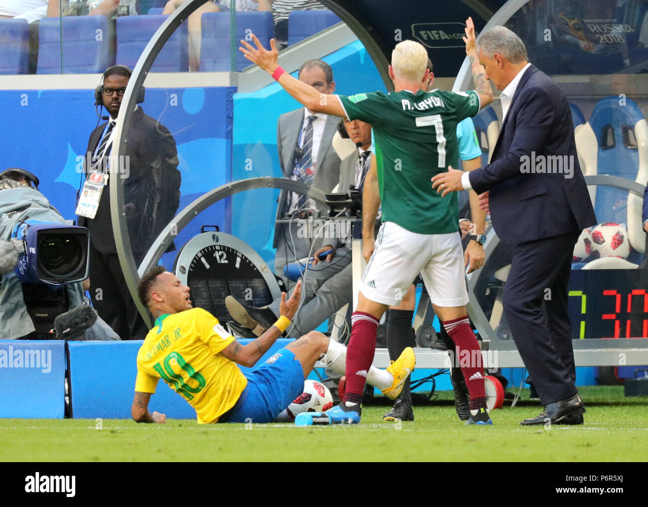 Samara, Russia. 02nd July, 2018. Soccer, World Cup 2018, Final round - round of 16: Mexico vs. Brazil at the Samara stadium: Brazil's Neymar (L) lying on the floor after a duel while Mexico's Miguel Layun and Brazil head coach Tite (R) argue. Credit: Christian Charisius/dpa/Alamy Live News Stock Photo