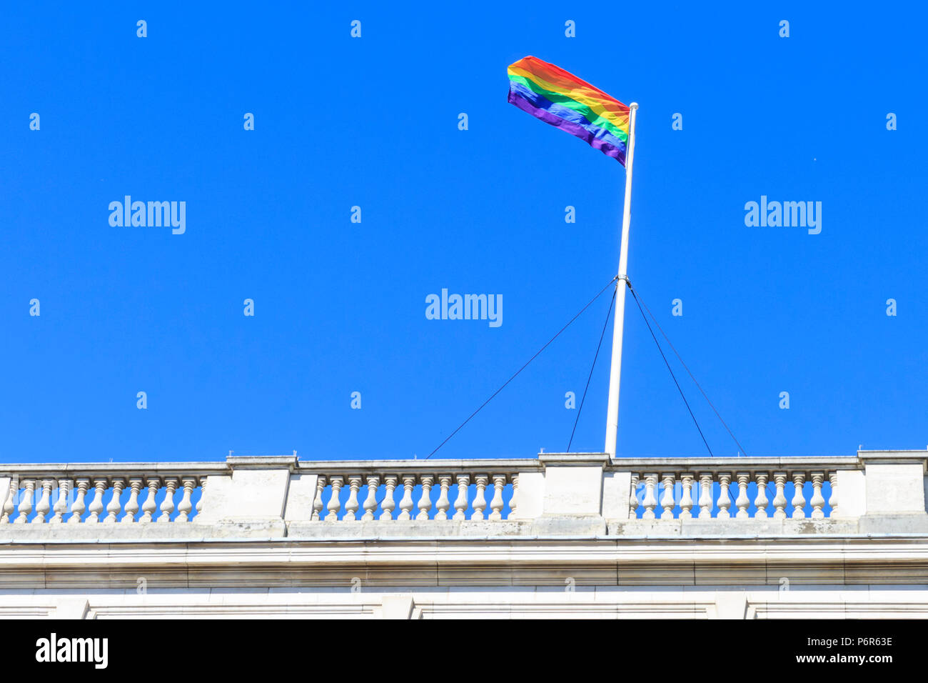 Westminster, London, UK, 2nd July 2018. The Pride flag on to of 55 Whitehall, with the statue of Prince George, Duke of Cambridge in the foreground. Pride flags in rainbow colours are displayed on top of many government and civil buildings and sights in the heart of the capital ahead of Pride in London events and the Pride March on July 7th. Credit: Imageplotter News and Sports/Alamy Live News Stock Photo