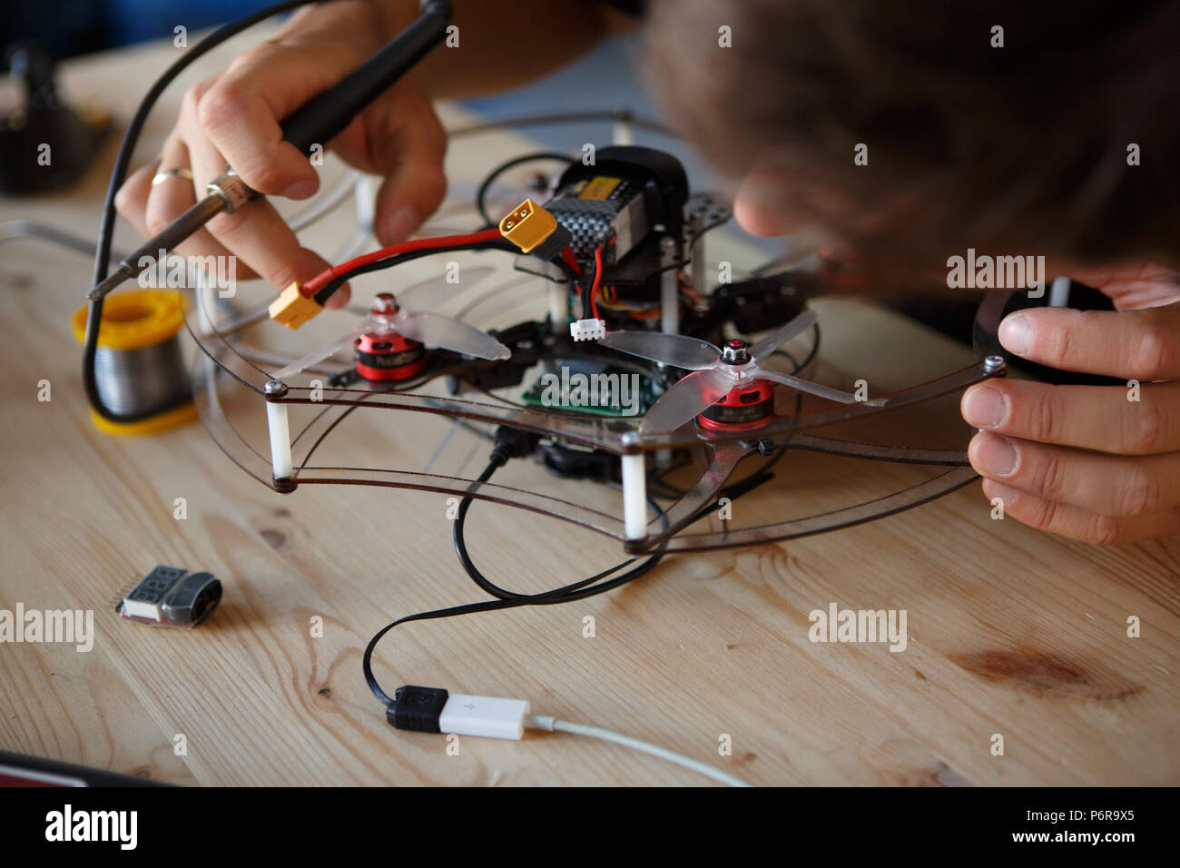 Image of young man with soldering iron chipping mechanism Stock Photo Alamy