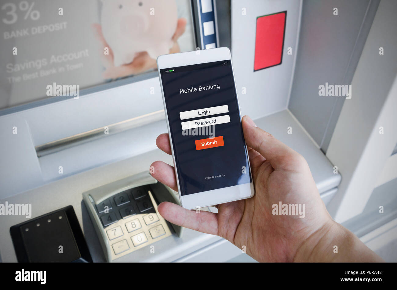 Withdraw money from an ATM without using a credit card. Person holding a phone with a login screen for mobile banking. Stock Photo