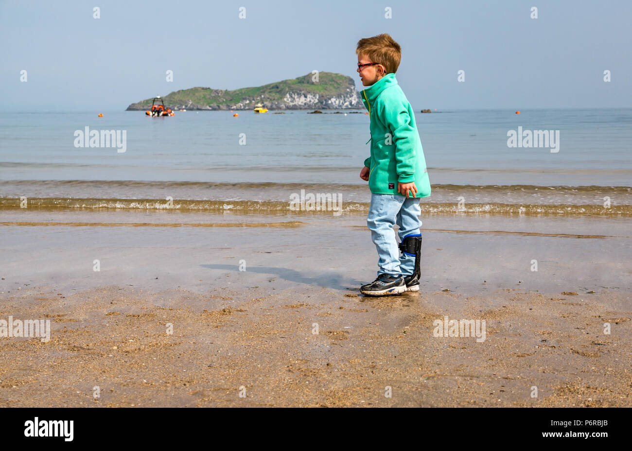 Boy with right hemiplegia wearing carbon fibre turbo drop leg brace on West beach, North Berwick, East Lothian, Scotland, UK Stock Photo
