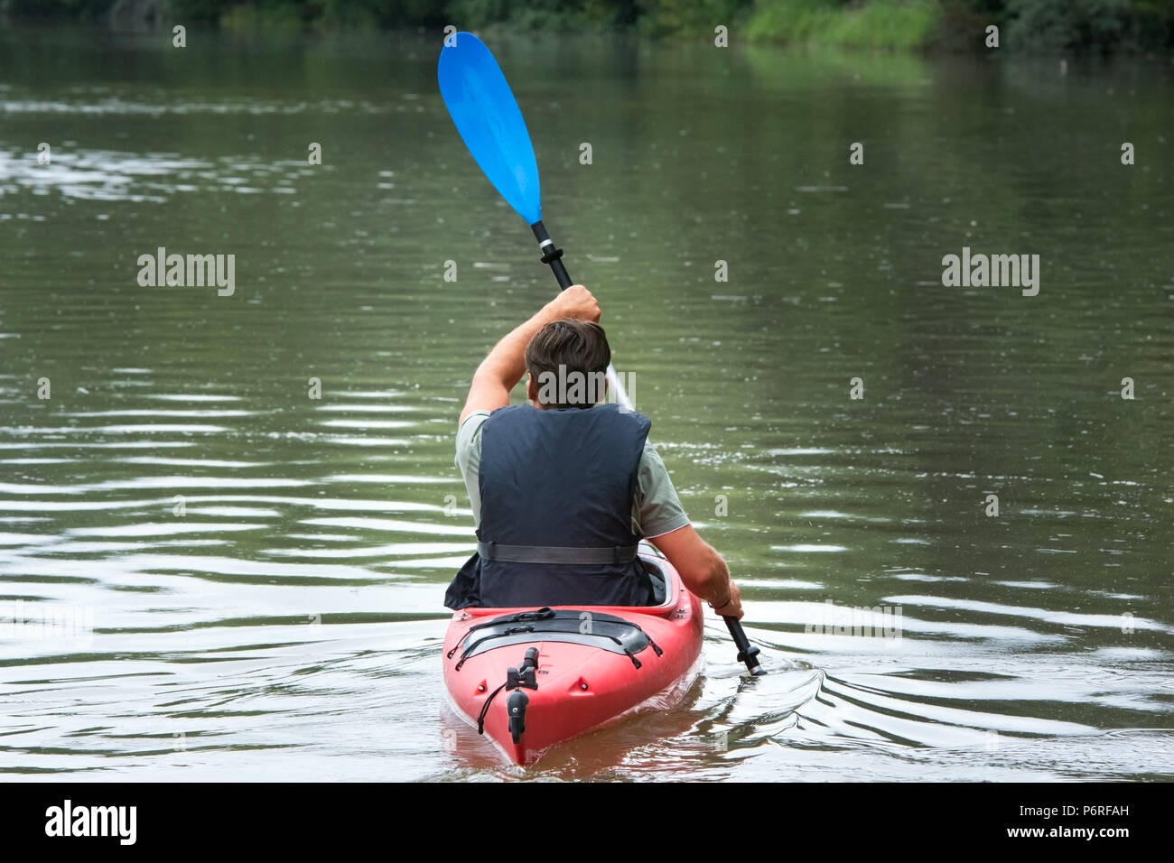 Adult male canoeing on mountain lake Stock Photo