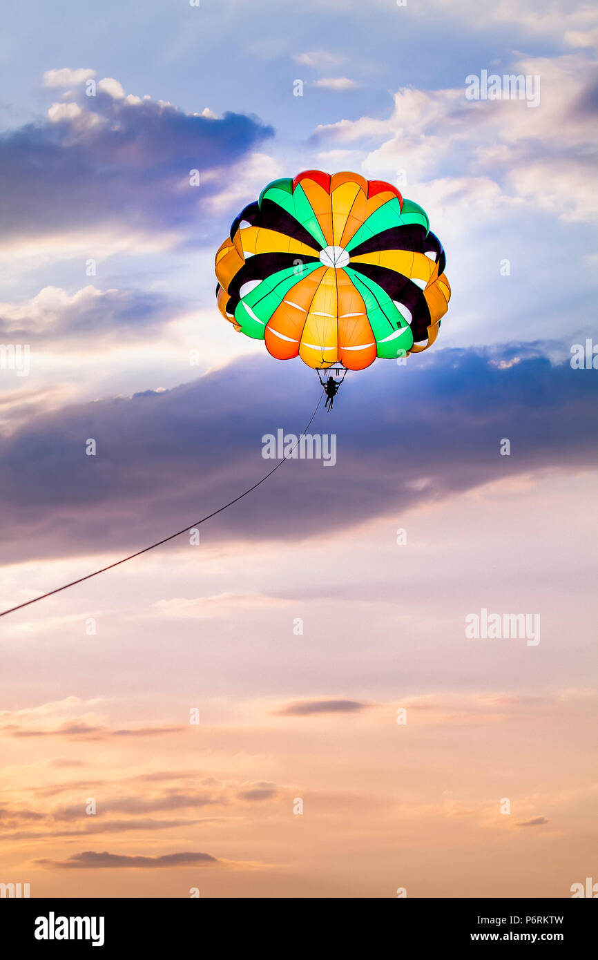 Parasailing against a pastel coloured sky at White Beach, Puerto Galera, Oriental Mindoro, Philippines. Stock Photo