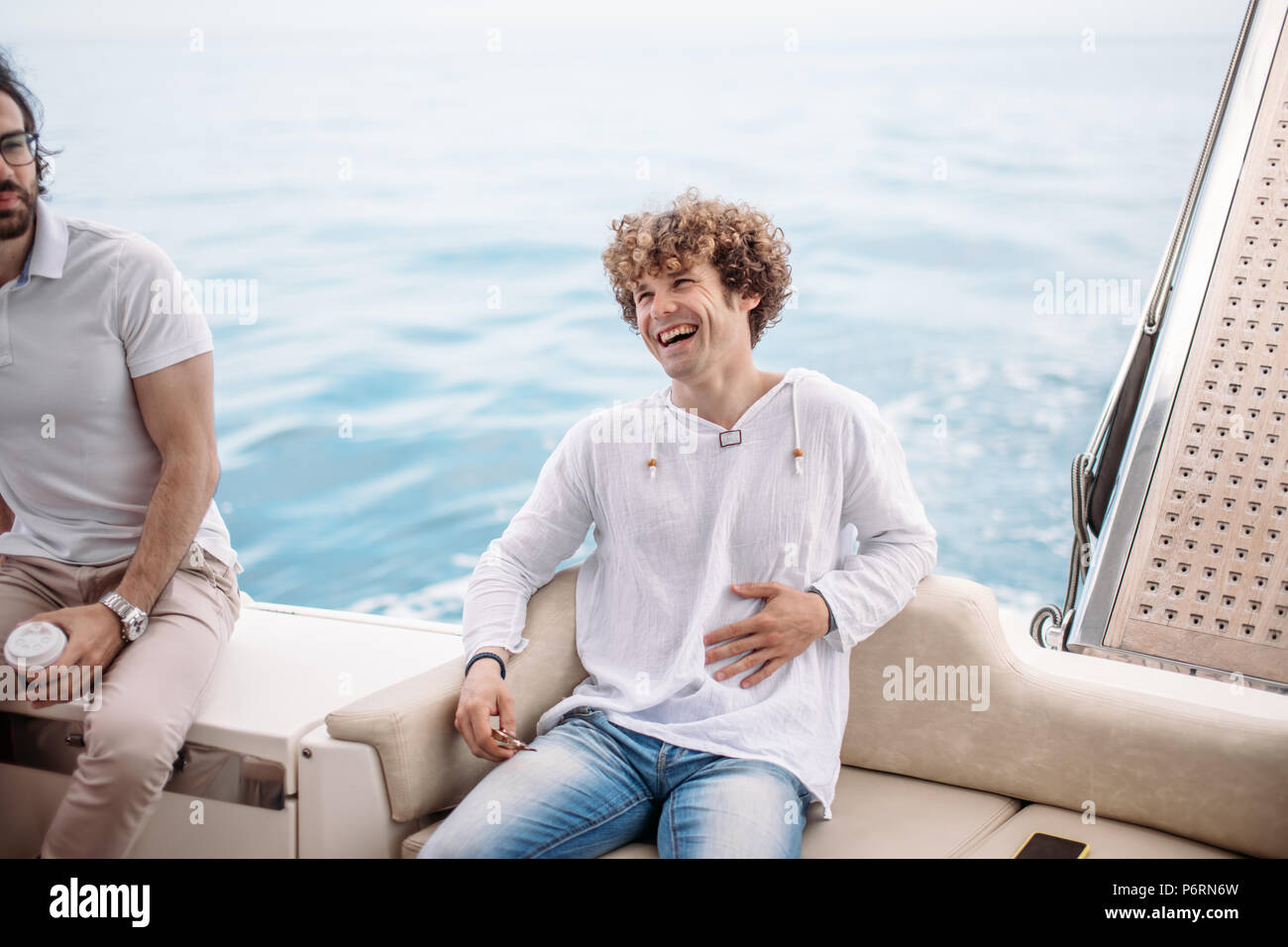 Happy handsome european guy with curly hair, dressed in marine style
