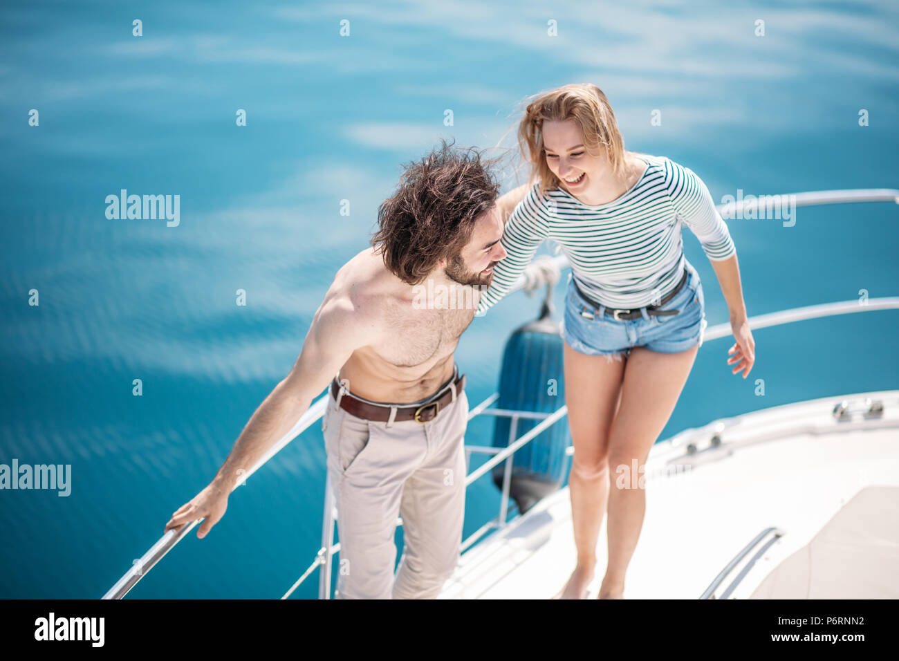 Romantic marine vacation and luxury travel. Young hot couple kissing on the modern yacht deck. Sailing the sea. Stock Photo