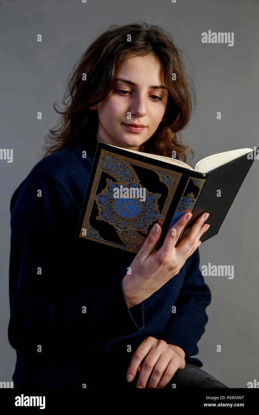 Young woman reading kuran. Paris, France. Stock Photo