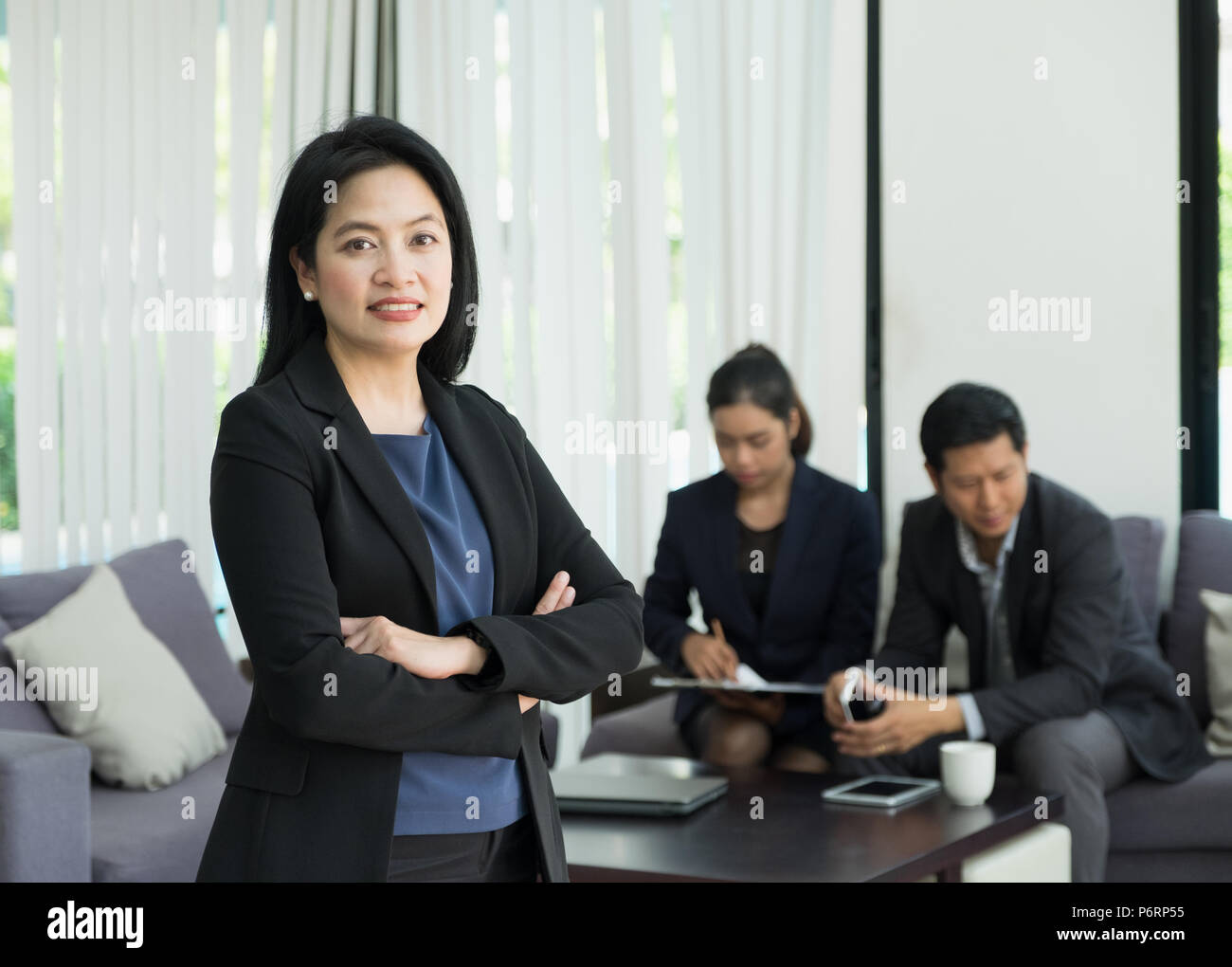 Businesswoman female leader standing and cross arm with team in