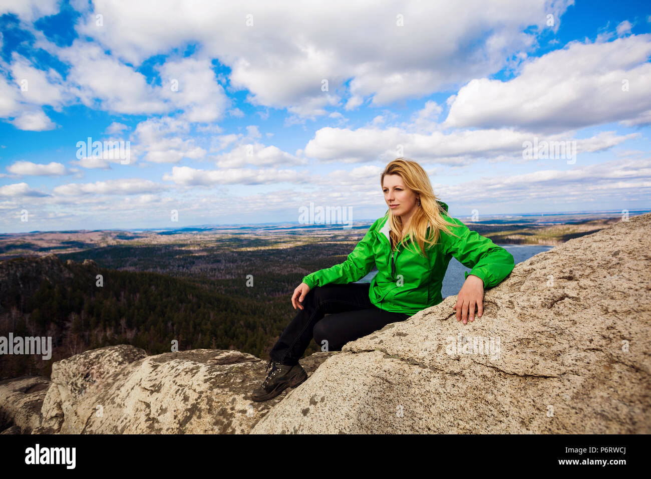 Young woman posing on cliff's edge. Stock Photo