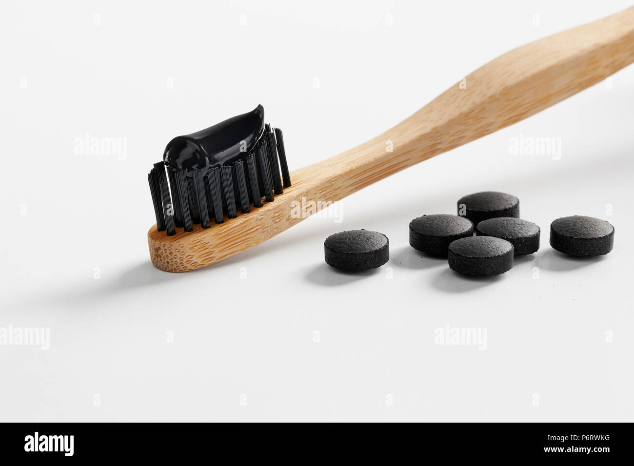 Toothbrush with black charcoal toothpaste. Black toothpaste on toothbrush  with activated charcoal pills Stock Photo - Alamy