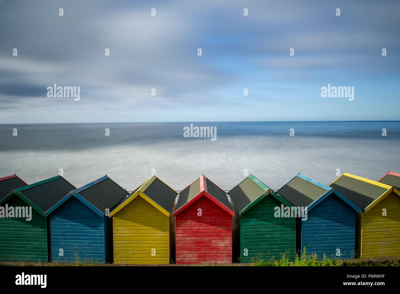 The multicoloured beach huts overlooking Whitby beach on the North Yorkshire coast. Stock Photo