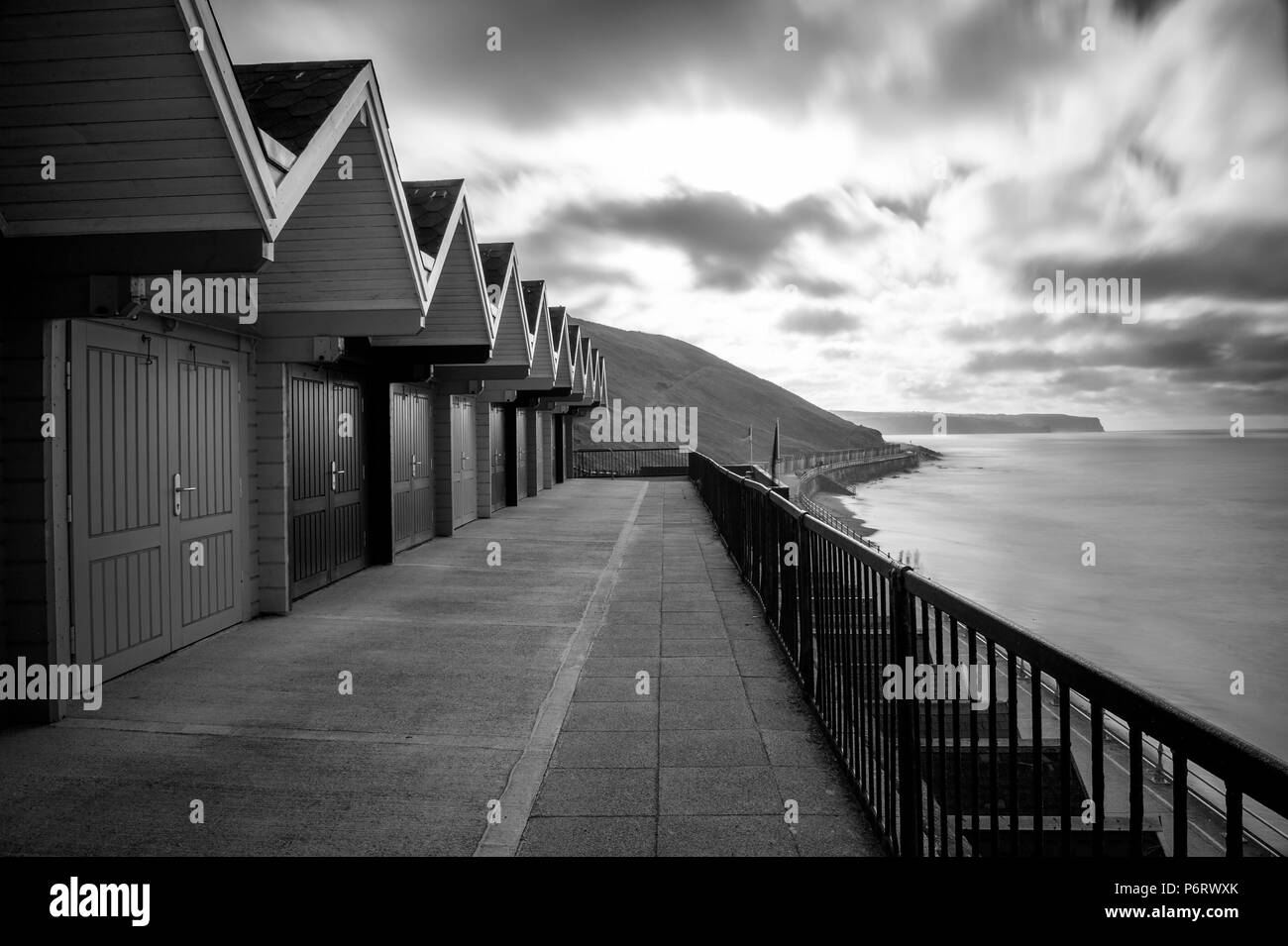 The multicoloured beach huts overlooking Whitby beach on the North Yorkshire coast. Stock Photo