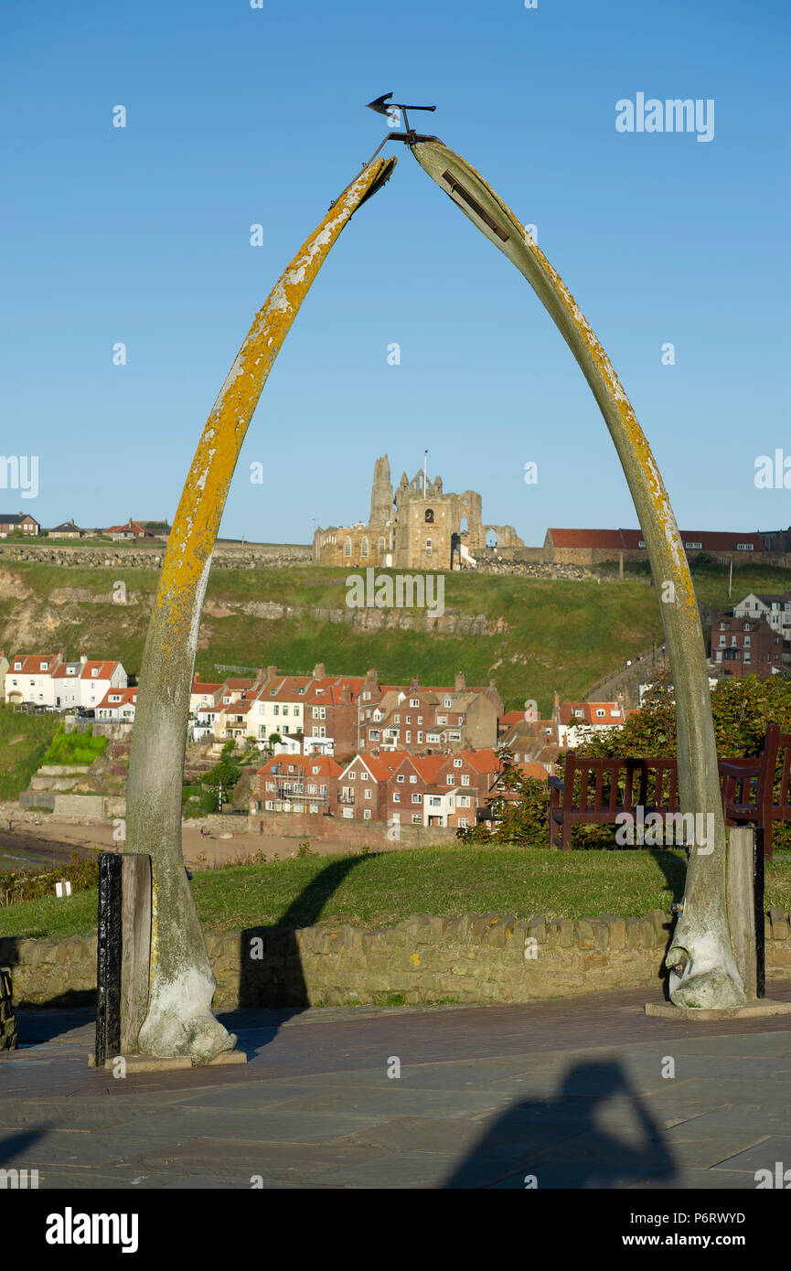 The Whitby Whale Bone Arch frames the view over the seaside town with the Church of St.Mary and Whitby Abbey on the hill top. Stock Photo