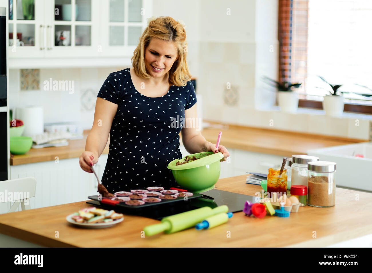 Beautiful pregnant woman baking muffins Stock Photo Alamy