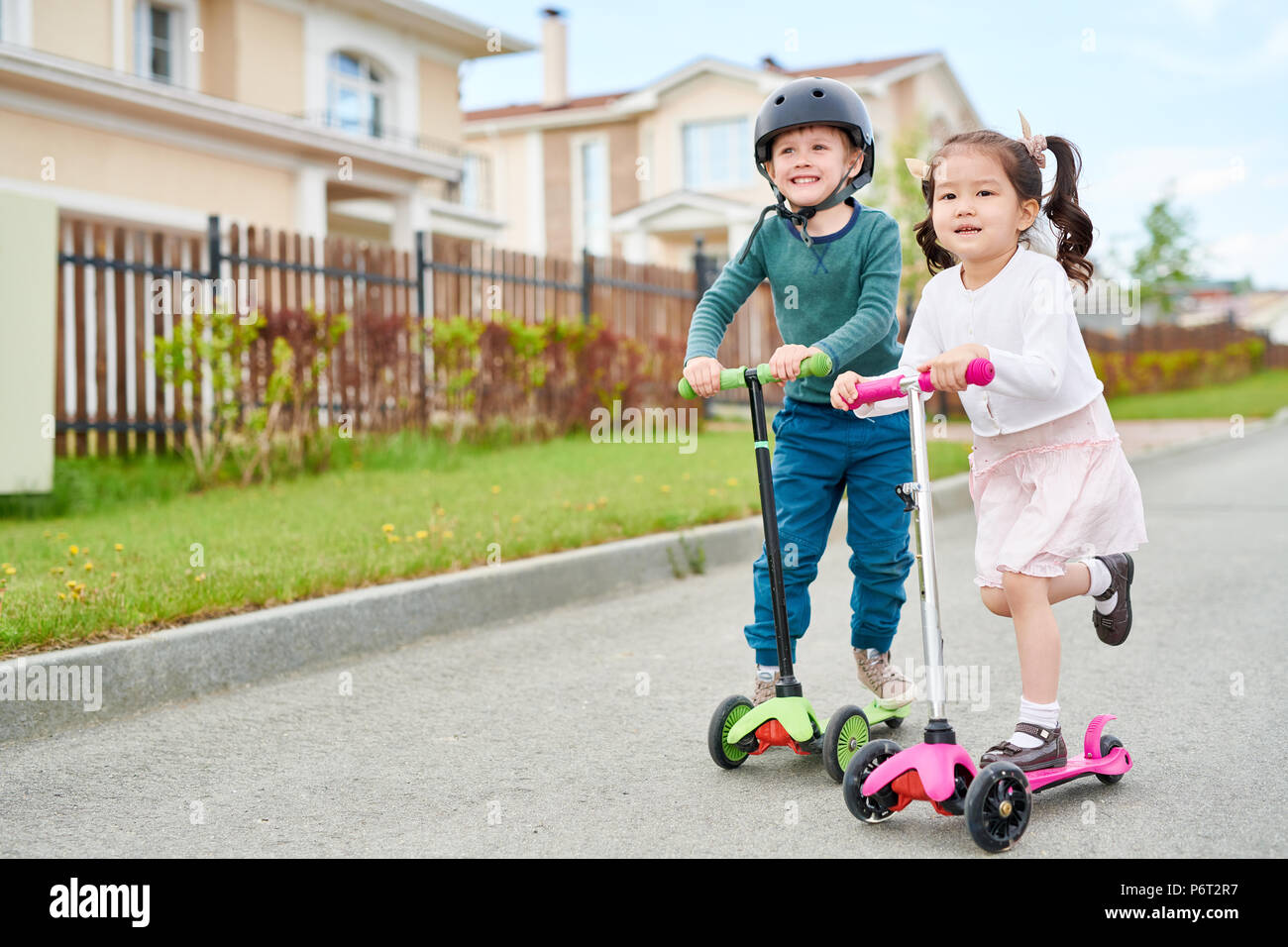 Cute Children Riding Scooters Stock Photo