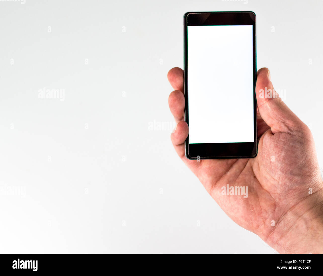 Closeup of male hand with a white screen smartphone on white background ...