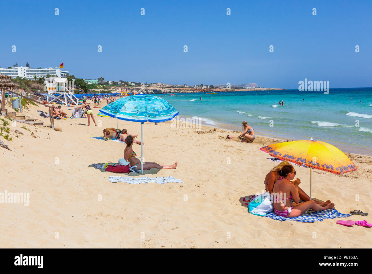 Tourists sunbathing on Karousos Beach, Ayia Napa, Cyprus Stock Photo