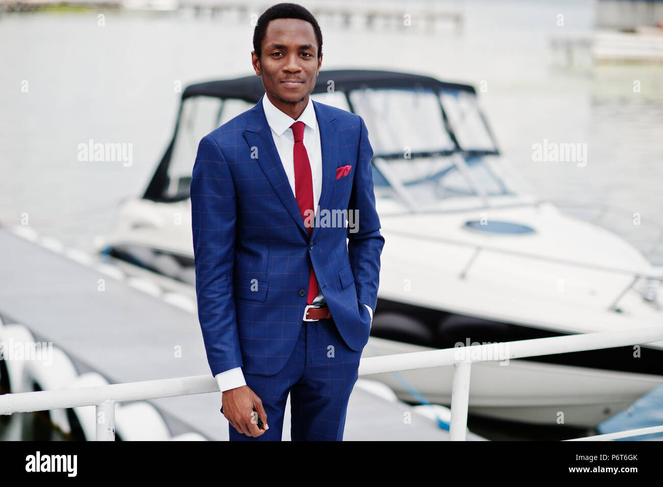 African american happy successful man at suit against yacht. Rich black ...