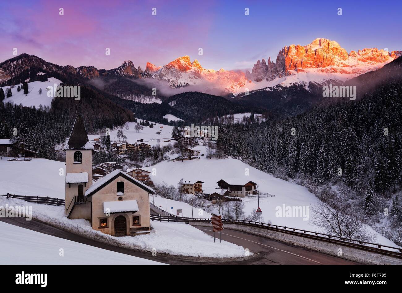 Winter Panorama of San Cipriano di Tires (northern Italy) at sunset, with the Catinaccio mountain on the background Stock Photo