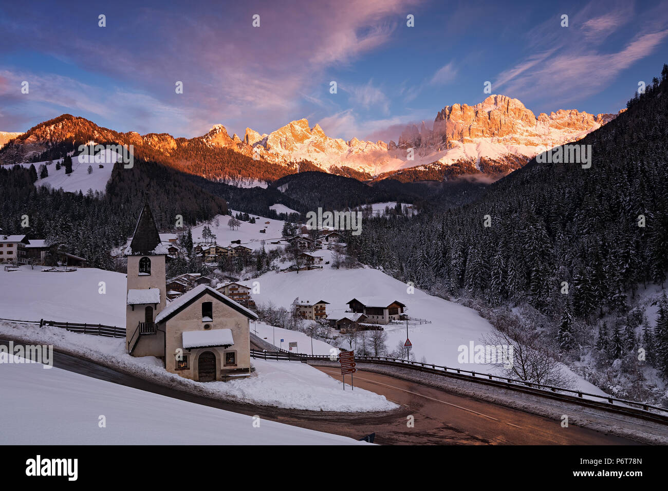 Winter Panorama of San Cipriano di Tires (northern Italy) at sunset, with the Catinaccio mountain on the background Stock Photo