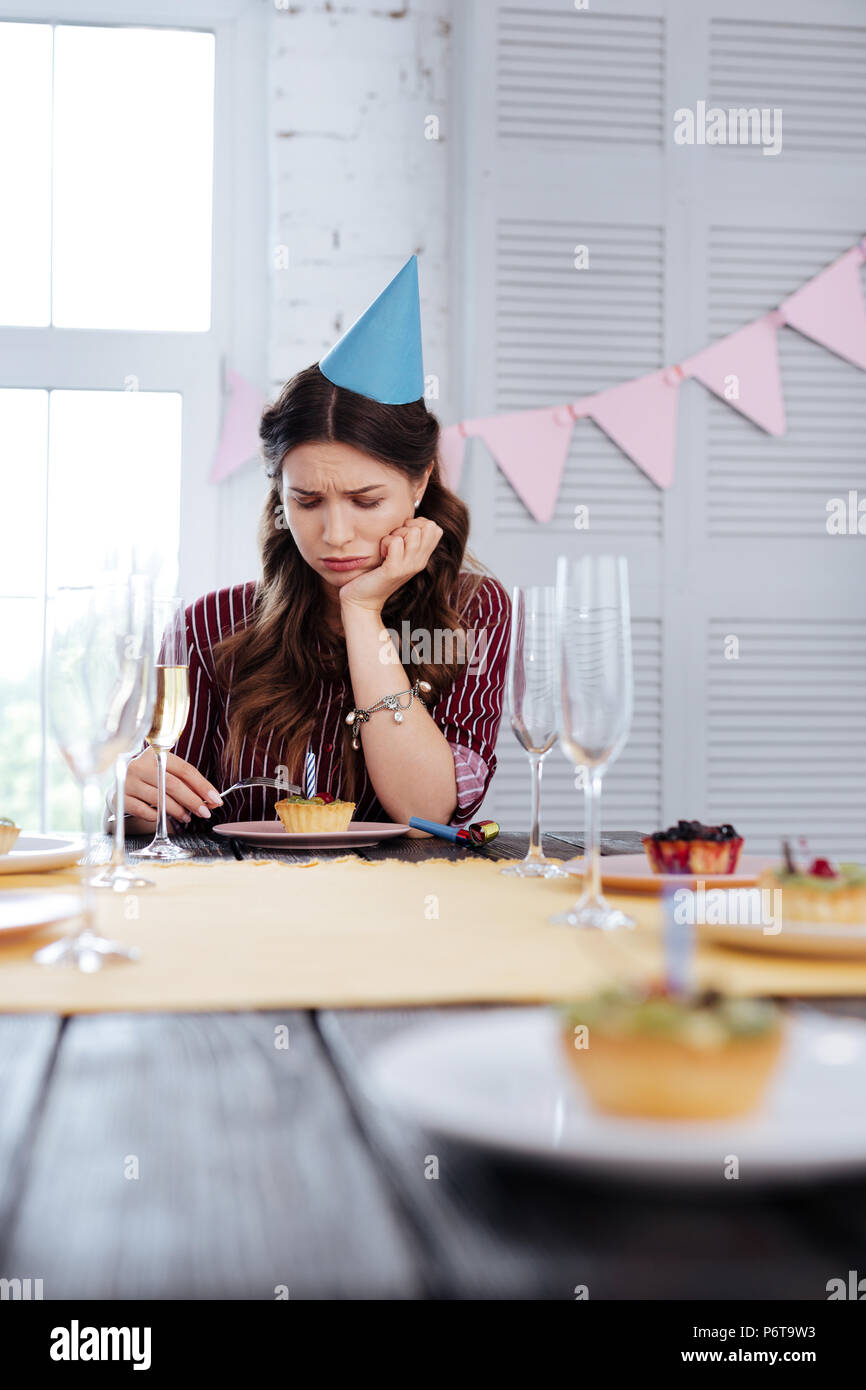 Dark-haired woman crying while feeling lonely on birthday Stock Photo