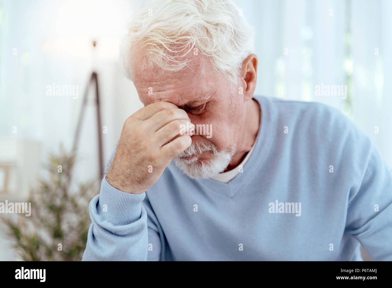 Unhappy senior man suffering from headache Stock Photo - Alamy