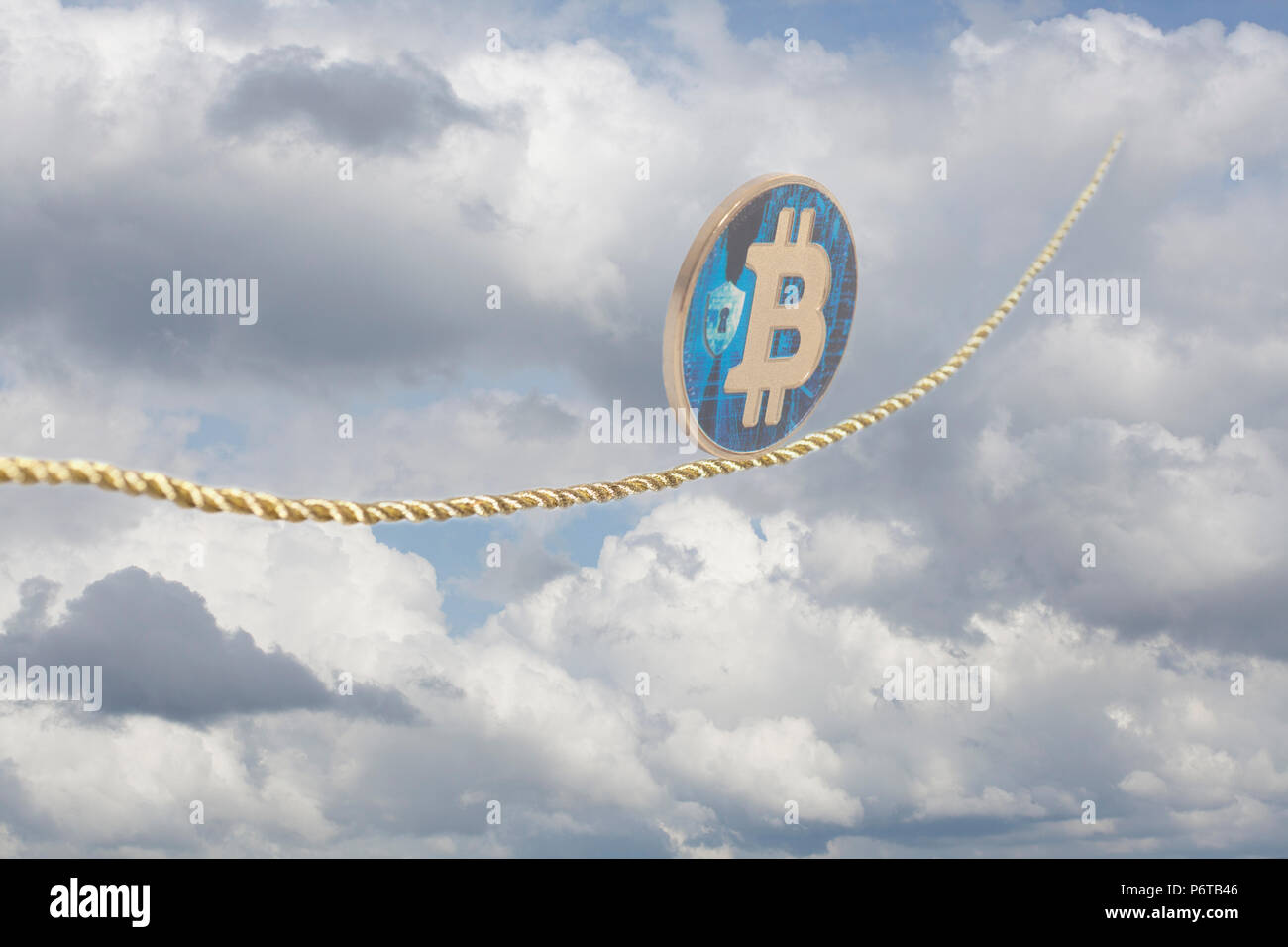 Bitcoin balancing on rope in the sky. Stock Photo