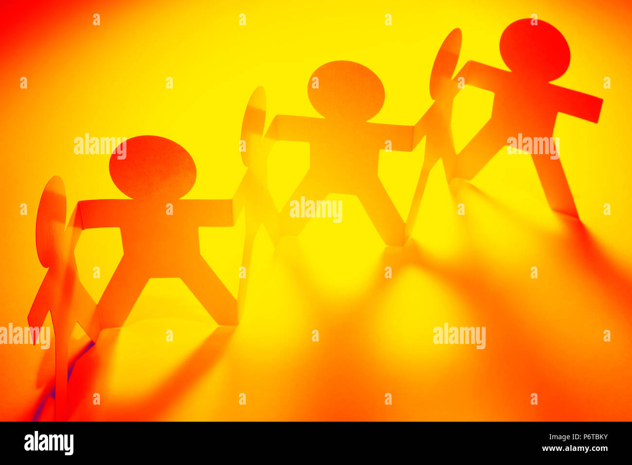 Team of paper chain people in a row holding hands Stock Photo - Alamy