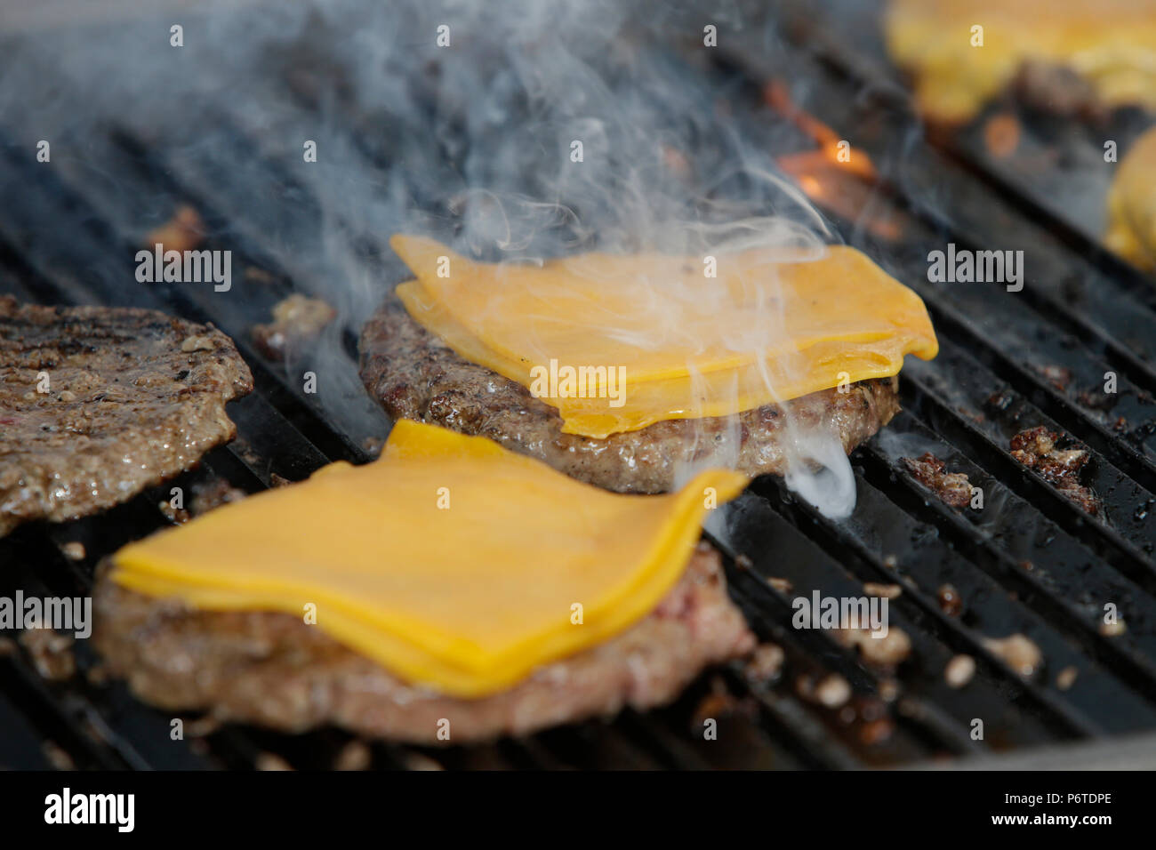 Hoppegarten, Germany, cheeseburgers are being prepared on a grill Stock Photo