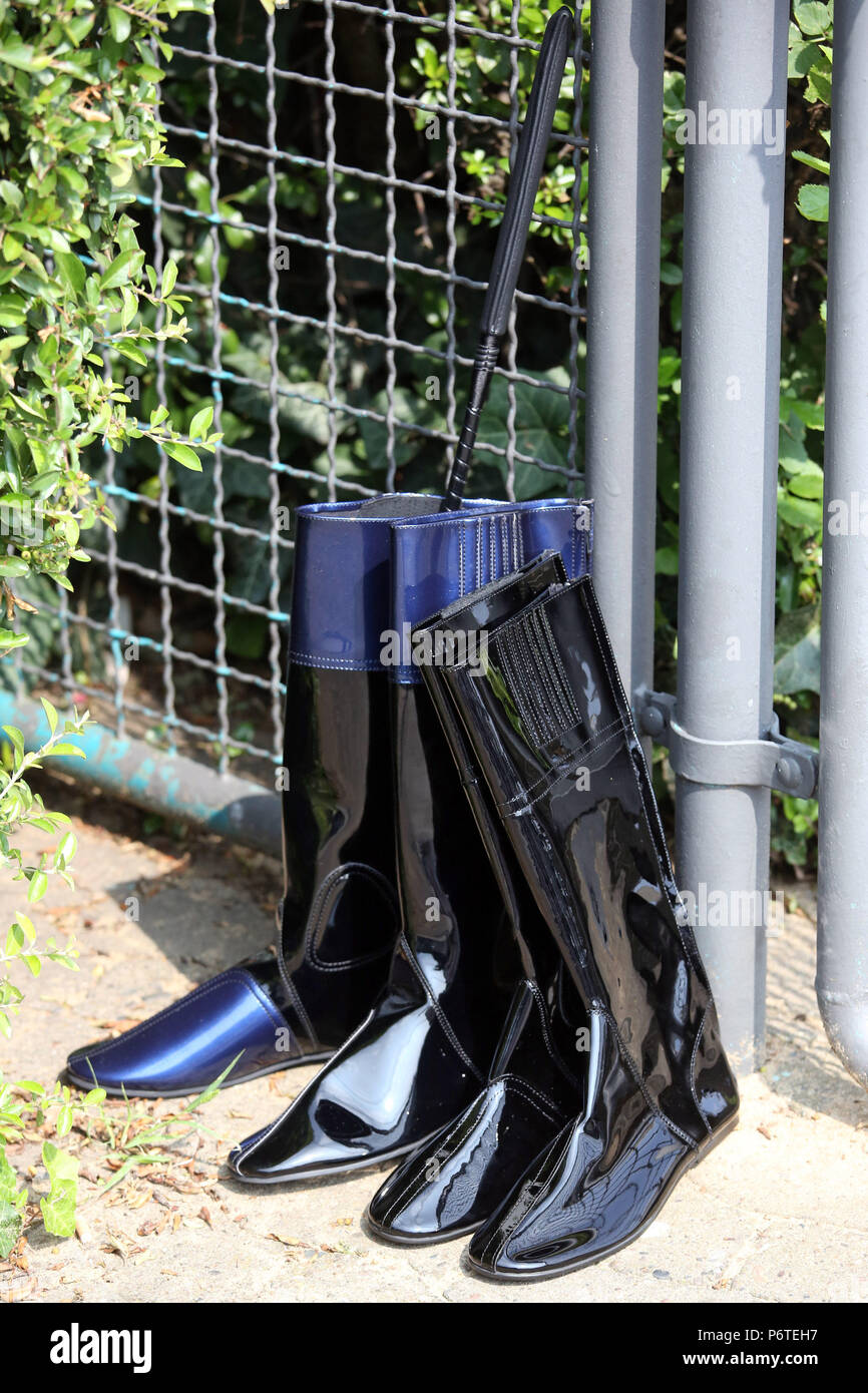 Hanover, jockey boots and whip lean against a fence Stock Photo
