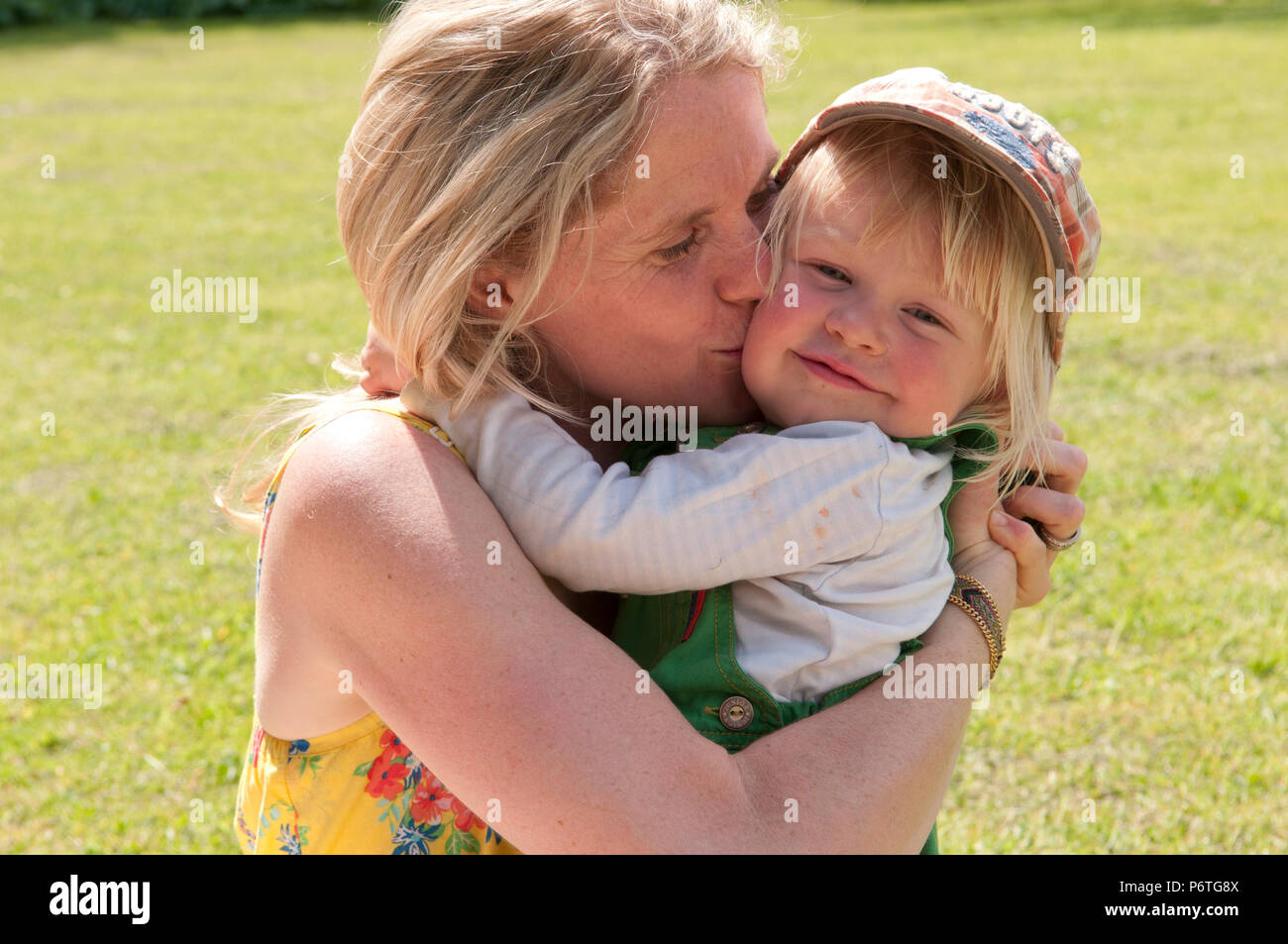 Mother cuddling her little boy outside Stock Photo - Alamy