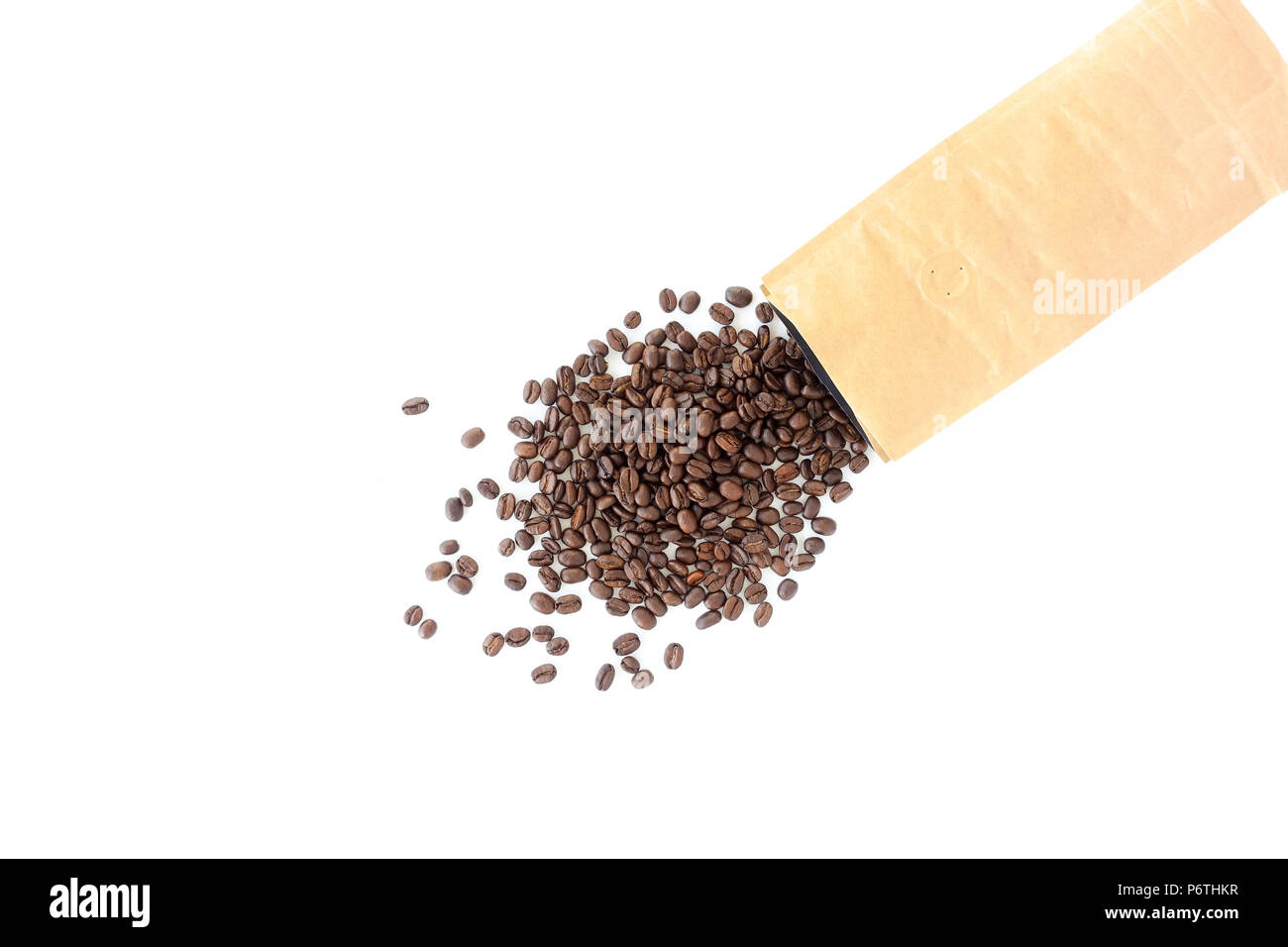 Brown paper bag filled with roasted coffee beans and scattered beans on ...