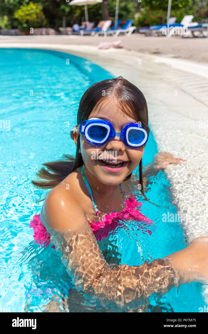Little girl wearing swimming glasses in swimming pool Stock Photo ...