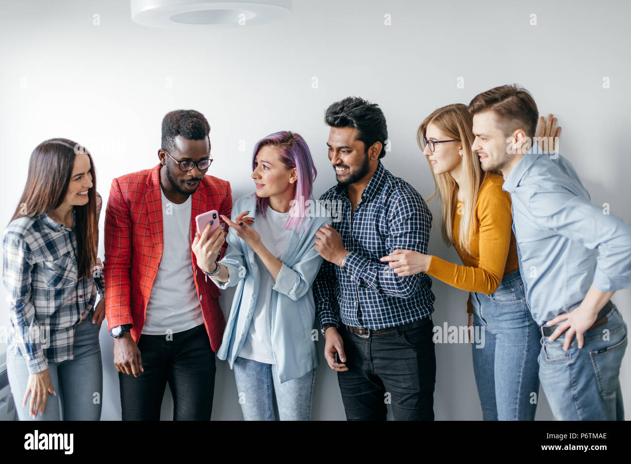 Multiethnic couples looking with curiosity at smartphone screen, in woman  hands People and Technology, Casual Community. Diversity and Togetherness  Co Stock Photo - Alamy