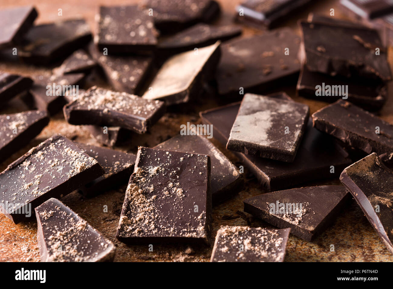 Broken chocolate pieces on brown background Stock Photo