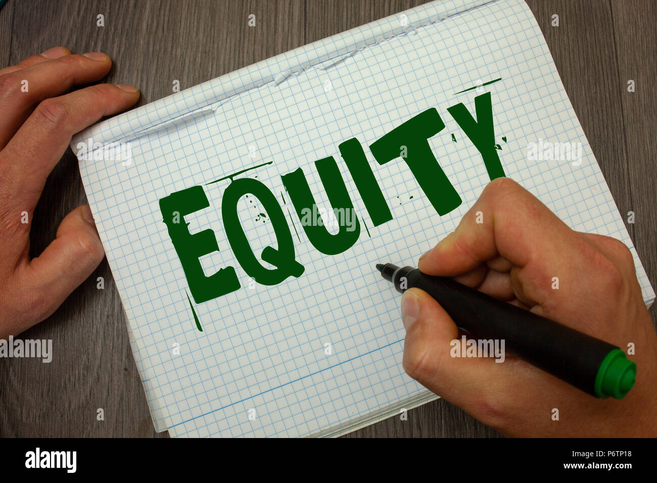 Conceptual hand writing showing Equity. Business photo text Value of a company divided into equal parts owned by shareholders Man hold holding black m Stock Photo
